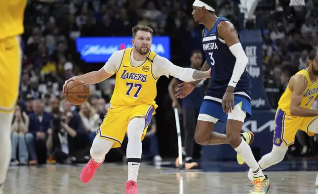 Los Angeles Lakers guard Luka Doncic (77) works toward the basket as Minnesota Timberwolves forward Jaden McDaniels (3) defends during the second half of Game 3 of an NBA basketball first-round playoff series, Friday, April 25, 2025, in Minneapolis. (AP Photo/Abbie Parr)