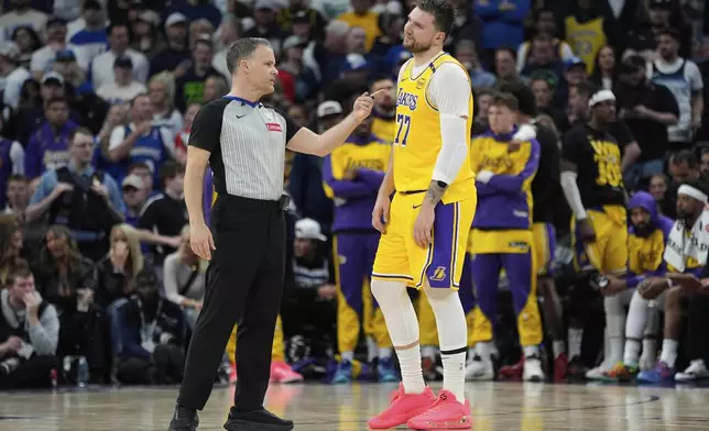 Los Angeles Lakers guard Luka Doncic (77) stands next to referee Mark Lindsay during the second half of Game 3 of an NBA basketball first-round playoff series against the Minnesota Timberwolves, Friday, April 25, 2025, in Minneapolis. (AP Photo/Abbie Parr)