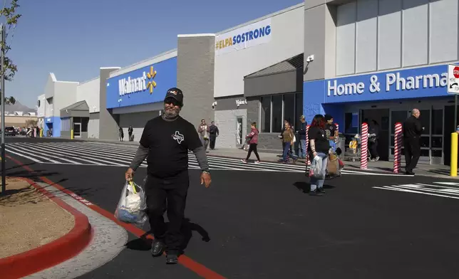 FILE - Eddie Medina, 62, carries groceries he bought for his wife at the reopening of the Cielo Vista Walmart, Thursday, Nov. 14, 2019, in El Paso, Texas. (AP Photo/Cedar Attanasio, File)
