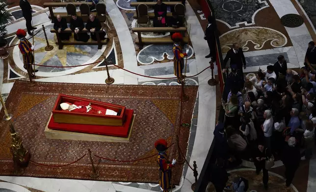 People queue to pay their respects to the late Pope Francis, who will lie in state at St. Peter's Basilica for three days, at the Vatican, Wednesday, April 23, 2025. (Cecilia Fabiano/LaPresse via AP)