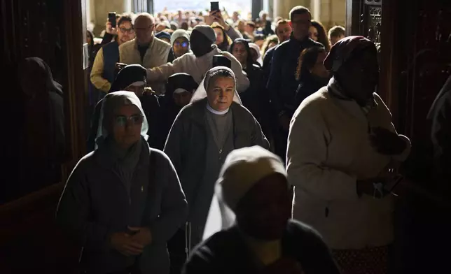 People line up as they enter St. Peter's Basilica to pay their respects to Pope Francis lying in state, at the Vatican, Thursday, April 24, 2025. (AP Photo/Emilio Morenatti)