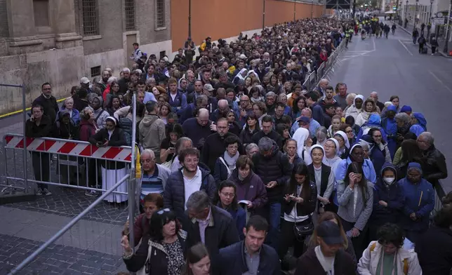 People wait in line to view Pope Francis lying in state inside St. Peter's Basilica, at the Vatican, Thursday, April 24, 2025. (AP Photo/Emilio Morenatti)