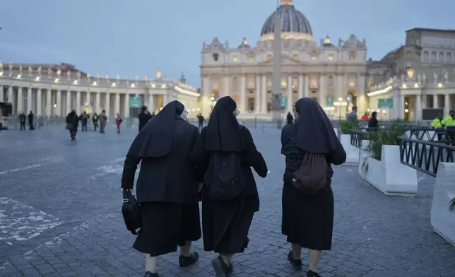 Nuns walk towards St. Peter's Baslica where Pope Francis is lying in state, at the Vatican, Thursday, April 24, 2025. (AP Photo/Markus Schreiber)