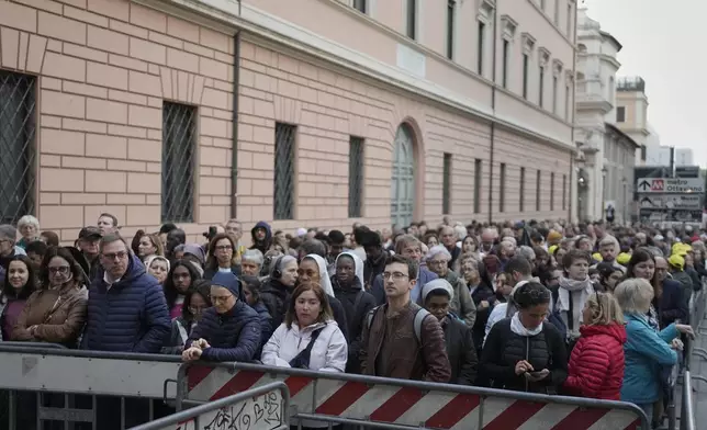 People wait in line to view Pope Francis lying in state inside St. Peter's Basilica, at the Vatican, Thursday, April 24, 2025. (AP Photo/Markus Schreiber)