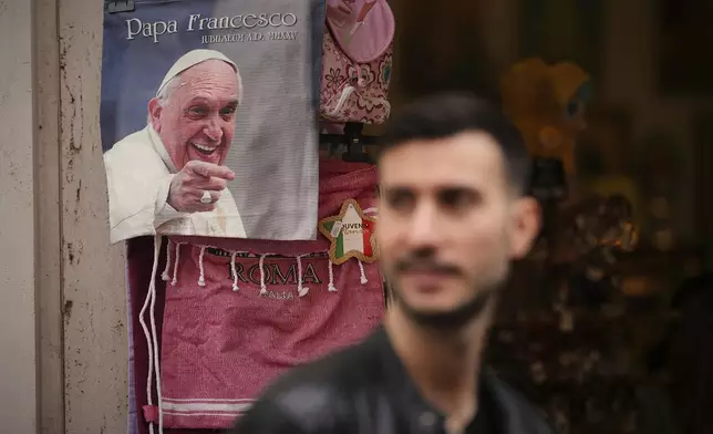 A photo of the late Pope Francis is printed on a bag on sale at a souvenir shop outside the Vatican, Thursday, April 24, 2025. (AP Photo/Andreea Alexandru)