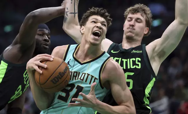 Charlotte Hornets' Tidjane Salaun (31) drives for the basket against Boston Celtics' Neemias Queta (88) and Baylor Scheierman (55) during the first half of an NBA basketball game Sunday, April 13, 2025, in Boston. (AP Photo/Michael Dwyer)