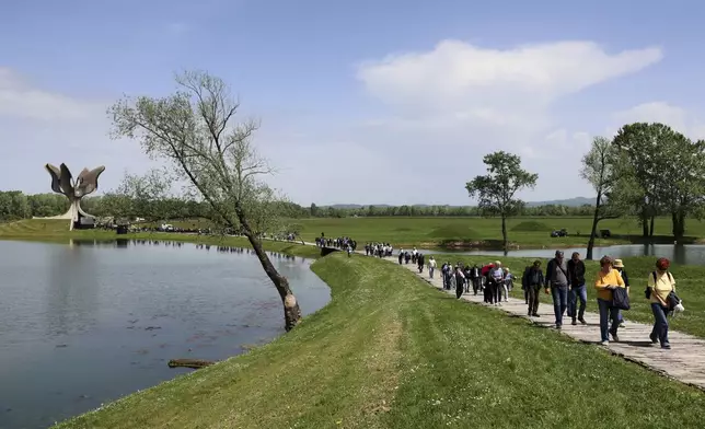 People walk away from the monument commemorating victims of a World War II concentration camp, where tens of thousands of people perished in the hands of the pro-Nazi puppet regime at the time, in Jasenovac, Croatia, Tuesday, April 22, 2025. (AP Photo)