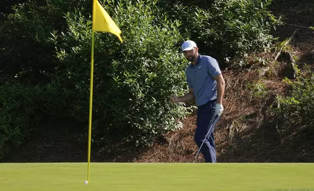 Scottie Scheffler celebrates after chipping in for birdie on the 12th hole during the second round at the Masters golf tournament, Friday, April 11, 2025, in Augusta, Ga. (AP Photo/Ashley Landis)