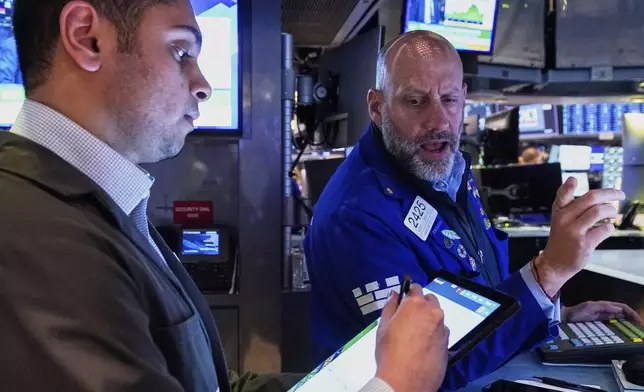 Trader Niall Pawa, left, and Specialist Meric Greenbaum work on the floor of the New York Stock Exchange, Wednesday, April 23, 2025. (AP Photo/Richard Drew)