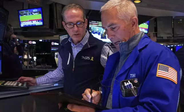 Specialist Glenn Carell, left, and trader Timothy Nick work on the floor of the New York Stock Exchange, Wednesday, April 23, 2025. (AP Photo/Richard Drew)
