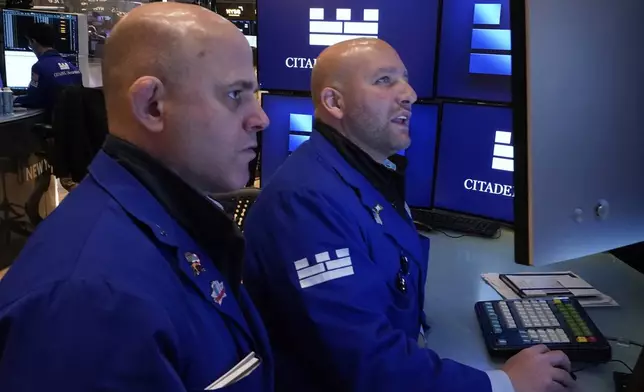 Specialists Mark Fitzgerald, left, and John Parisi confer on the floor of the New York Stock Exchange, Wednesday, April 23, 2025. (AP Photo/Richard Drew)