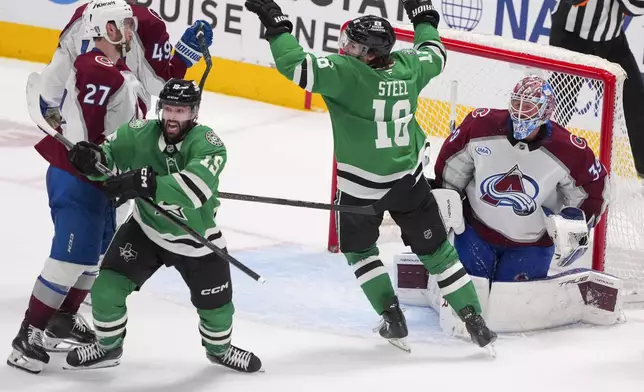 Dallas Stars center Colin Blackwell, left, and teammate center Sam Steel (18) react after Blackwell scored the game-wining goal on Colorado Avalanche goaltender Mackenzie Blackwood, second from right, during overtime in Game 2 of a first-round NHL hockey playoff series early Tuesday, April 22, 2025, in Dallas. (AP Photo/Julio Cortez)