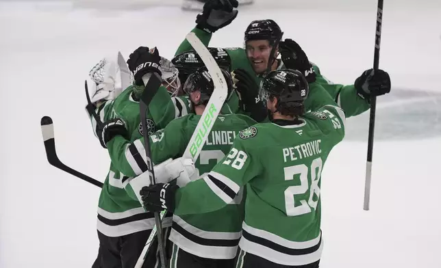Dallas Stars players celebrate a game-winning goal by Colin Blackwell, not pictured, during overtime in Game 2 of a first-round NHL hockey playoff series against the Colorado Avalanche early Tuesday, April 22, 2025, in Dallas. (AP Photo/Julio Cortez)