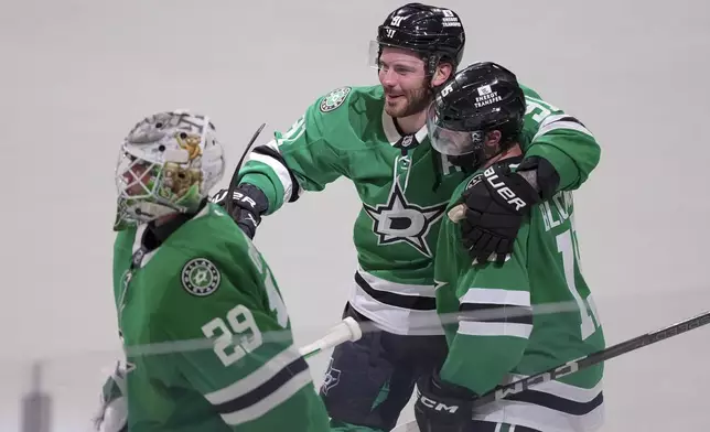 Dallas Stars center Colin Blackwell, right, is congratulated by teammates center Tyler Seguin (91) and goaltender Jake Oettinger (29) after scoring the game-winning goal against the Colorado Avalanche during overtime in Game 2 of a first-round NHL hockey playoff series early Tuesday, April 22, 2025, in Dallas. (AP Photo/Julio Cortez)