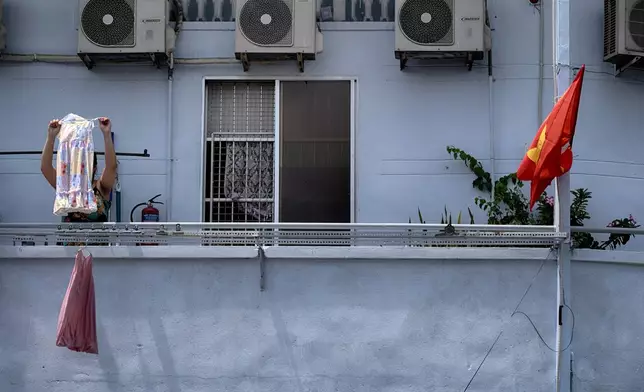 A woman hangs her laundry in the morning in the Cholon district of Ho Chi Minh City, Vietnam, on Tuesday, April 29, 2025 ahead of the 50th anniversary of the end of the Vietnamese War. (AP Photo/Richard Vogel)