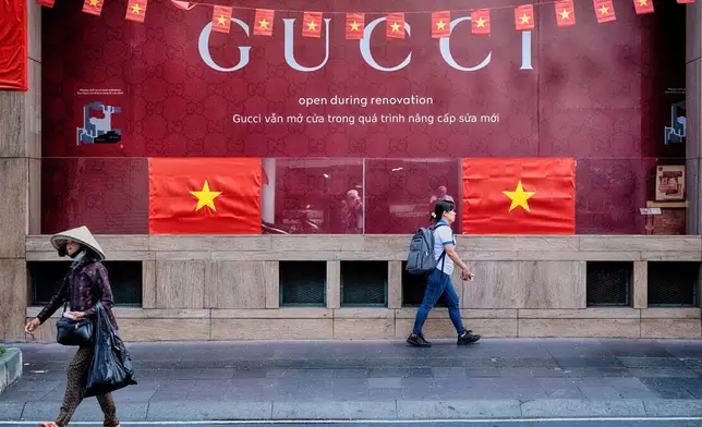 People walk past a Gucci shop in central Ho Chi Minh City, Vietnam, on Tuesday, April 29, 2025 ahead of the 50th anniversary of the end of the Vietnamese War. (AP Photo/Richard Vogel)