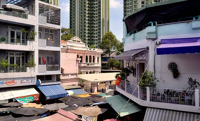 High-rise buildings tower over an umbrella-covered market in the Cholon district of Ho Chi Minh City, Vietnam, Tuesday, April 29, 2025, ahead of the 50th anniversary of the end of the Vietnamese War. (AP Photo/Richard Vogel)