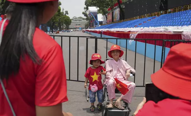 A woman and her grandchild take photos at the venue for a parade to be held on April 30 to celebrate the 50th anniversary of the end of the Vietnam War in Ho Chi Minh City, Vietnam Tuesday, April 29, 2025. (AP Photo/Hau Dinh)
