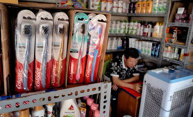 A vendor selling Colgate toothpaste and other U.S. made sundry items waits for customers at the Cholon market in the Cholon district of Ho Chi Minh City, Vietnam, on Tuesday, April 29, 2025 ahead of national celebration of the 50th Anniversary of reunification and the end of the Vietnam War. (AP Photo/Richard Vogel)