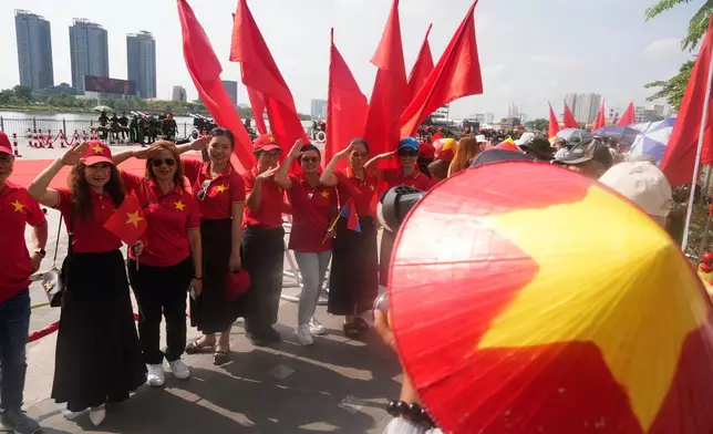 People in Vietnam flag T-shirts pose in front of a line of cannons used for the 50th anniversary of the end of the Vietnam War in Ho Chi Minh City, Vietnam Tueday, April 29, 2025. (AP Photo/Hau Dinh)