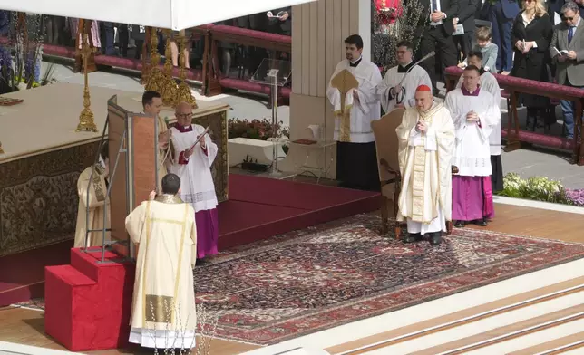 Cardinal Angelo Comastri, right, presides over the Easter mass in St. Peter's Square at the Vatican Sunday, April 20, 2025. (AP Photo/Gregorio Borgia)