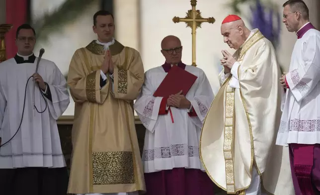 Cardinal Angelo Comastri, second from right, presides over the Easter mass in St. Peter's Square at the Vatican Sunday, April 20, 2025. (AP Photo/Andrew Medichini)