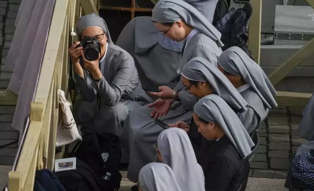 Nuns wait for the start of the Easter mass in St. Peter's Square at the Vatican Sunday, April 20, 2025. (AP Photo/Gregorio Borgia)