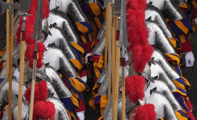 Pontifical Swiss guards arrive for the Easter mass in St. Peter's Square at the Vatican Sunday, April 20, 2025. (AP Photo/Gregorio Borgia)