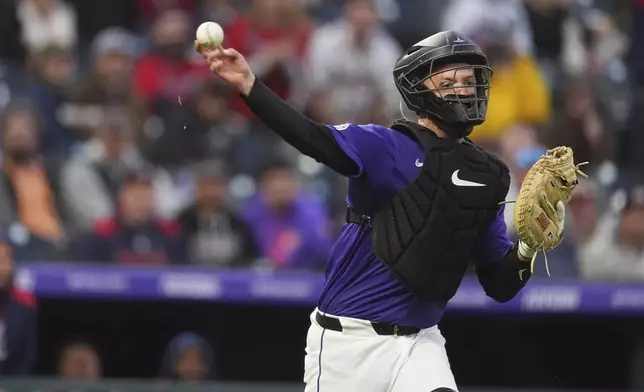 Colorado Rockies catcher Jacob Stallings throws to first base after fielding an infield single hit by Atlanta Braves' Eli White in the fourth inning of a baseball game Monday, April 28, 2025, in Denver. (AP Photo/David Zalubowski)