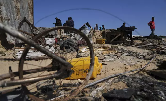 Palestinians inspect the remains of a displacement tent hit by an Israeli airstrike overnight, killing 10 members of the Abu Al-Rous family, in Khan Younis, southern Gaza Strip, Thursday, April 17, 2025. (AP Photo/Abdel Kareem Hana)