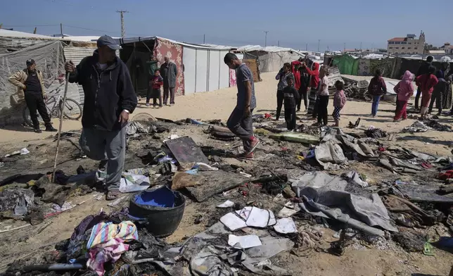 Palestinians inspect the remains of a displacement tent hit by an Israeli airstrike overnight, killing 10 members of the Abu Al-Rous family, in Khan Younis, southern Gaza Strip, Thursday, April 17, 2025. (AP Photo/Abdel Kareem Hana)