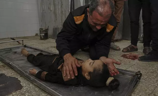 EDS NOTE: GRAPHIC CONTENT - Ahmed Dalloul mourns over the body of his 4-year-old daughter, Siwar, who was killed in an Israeli airstrike, at the morgue of Al-Aqsa Hospital in Deir al-Balah, central Gaza Strip, Thursday, April 17, 2025. (AP Photo/Abdel Kareem Hana)