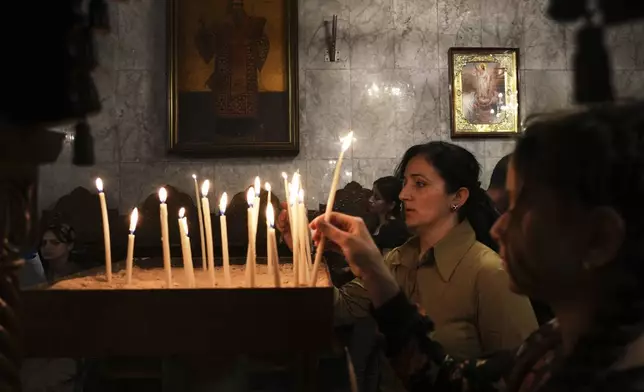 Palestinian Christians light candles during Good Friday mass at the Greek Orthodox Church of Saint Porphyrius in Gaza City, Friday, April 18, 2025. (AP Photo/Jehad Alshrafi)