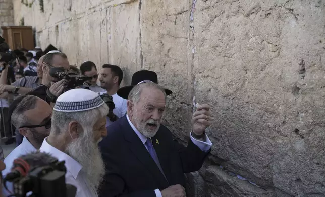 The US ambassador to Israel Mike Huckabee holds a note given to him from US President Donald Trump to be placed in the cracks of the Western Wall, the holiest site where Jews can pray, in the Old City of Jerusalem, Friday, April 18, 2025. (AP Photo/Leo Correa)