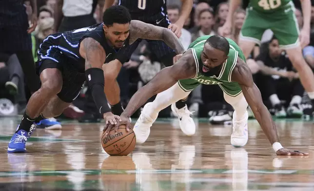 Boston Celtics guard Jaylen Brown, right, battles for a loose ball against Orlando Magic guard Gary Harris, left, during the first half in game 2 of a first-round NBA playoff basketball series, Wednesday, April 23, 2025, in Boston. (AP Photo/Charles Krupa)