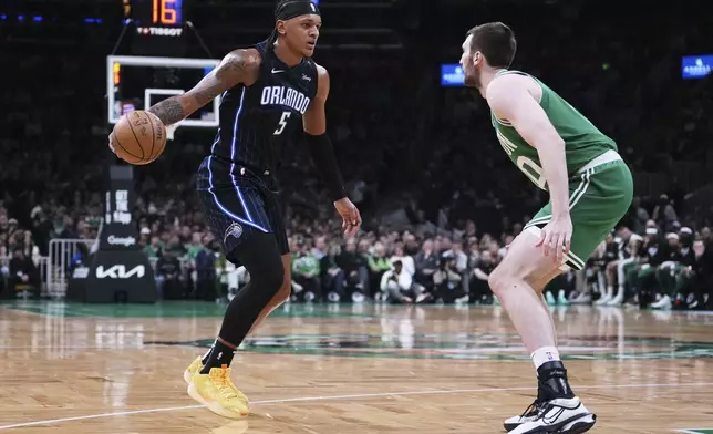 Orlando Magic forward Paolo Banchero (5) drives to the basket against Boston Celtics center Luke Kornet, right, during the first half in game 2 of a first-round NBA playoff basketball series, Wednesday, April 23, 2025, in Boston. (AP Photo/Charles Krupa)
