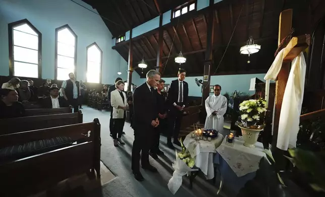 Liberal Leader Mark Carney visits St. Mary the Vigil South Hill Church with British Columbia Premier David Eby, Vancouver Mayor Ken Sim, hidden, and MLA Mable Elmore as Fr. Expedito Farinas looks on in Vancouver, B.C., after a vehicle drove into a crowd during a Filipino heritage festival, in Vancouver, British Columbia, Sunday, April 27, 2025. (Sean Kilpatrick/The Canadian Press via AP)