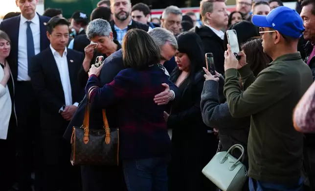 Liberal Leader Mark Carney, center, hugs a Filipino community member as he visits a memorial for victims after a vehicle drove into a crowd during a Filipino heritage festival in Vancouver, British Columbia, Sunday, April 27, 2025. (Sean Kilpatrick/The Canadian Press via AP)