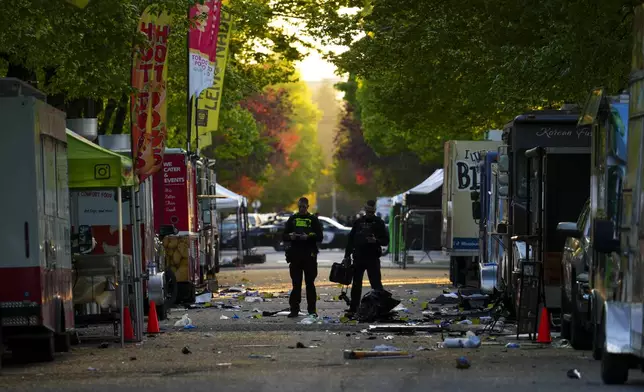 Members of the Vancouver Police forensics team examines the scene where a vehicle drove into a crowd during a Filipino heritage festival in Vancouver, British Columbia, Sunday, April 27, 2025. (Sean Kilpatrick/The Canadian Press via AP)