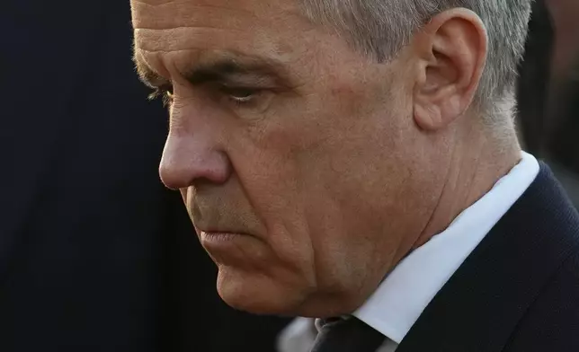 Liberal Leader Mark Carney takes a moment as he visits a memorial for victims after a vehicle drove into a crowd during a Filipino heritage festival in Vancouver, British Columbia, Sunday, April 27, 2025. (Sean Kilpatrick/The Canadian Press via AP)