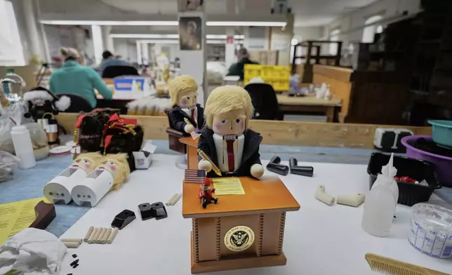 The limited-edition nutcrackers titled "Resolute Desk of the President," featuring a seated figure signing a "presidential proclamation," is seen at the Steinbach-Volkskunst nutcracker factory in Marienberg, Germany, Tuesday, April 15, 2025. (AP Photo/Markus Schreiber)