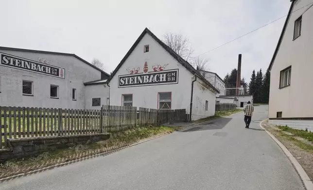A man walks on the road near the Steinbach-Volkskunst nutcracker factory in Marienberg, Germany, Tuesday, April 15, 2025. (AP Photo/Markus Schreiber)