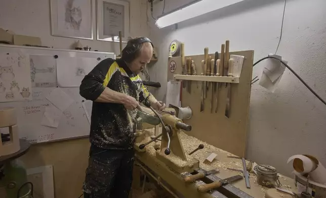 A man works on a lathe in the carpentry of the Steinbach-Volkskunst nutcracker factory in Marienberg, Germany, Tuesday, April 15, 2025. (AP Photo/Markus Schreiber)