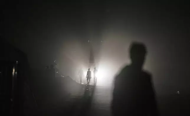 Palestinians walk at the Islamic University in Gaza City, which is now a shelter for displaced Palestinians amid the ongoing war in Gaza, Sunday, April 6, 2025. (AP Photo/Jehad Alshrafi)