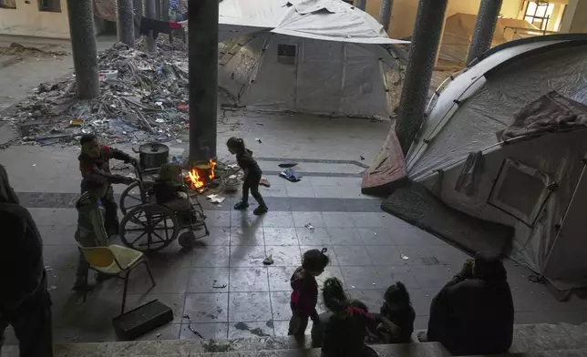 Displaced Palestinians sit by their tents at the Islamic University in Gaza City amid the ongoing war in Gaza, Friday, April 4, 2025. (AP Photo/Jehad Alshrafi)