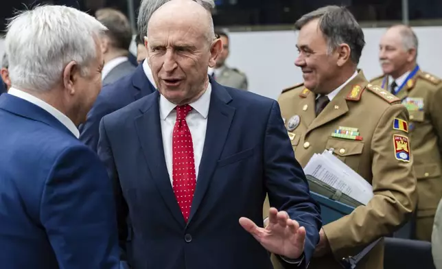 Britain's Defense Secretary John Healey, center, talks with Romania's Defense Minister Angel Tilvar as they arrive for a coalition of the willing defence ministers meeting at NATO headquarters in Brussels, Belgium, Thursday, April 10, 2025. (AP Photo/Geert Vanden Wijngaert)