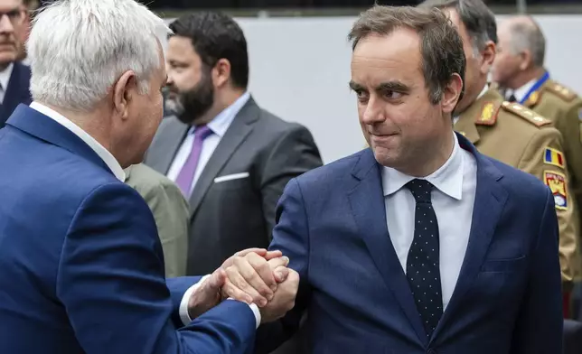 French Defense Minister Sebastien Lecornu, right, talks with Romania's Defense Minister Angel Tilvar as they arrive for a coalition of the willing defence ministers meeting at NATO headquarters in Brussels, Belgium, Thursday, April 10, 2025. (AP Photo/Geert Vanden Wijngaert)