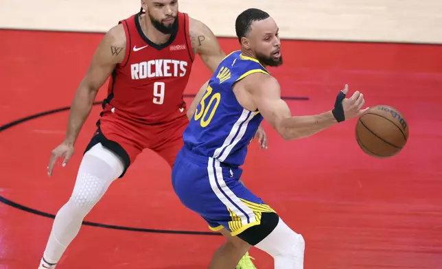 Golden State Warriors' Stephen Curry (30) has a pass go off his hand for a turnover while being defended by Houston Rockets' Dillon Brooks (9) during the first half of Game 1 of an NBA basketball first-round playoff series in Houston, Sunday, April 20, 2025. (Scott Strazzante/San Francisco Chronicle via AP)
