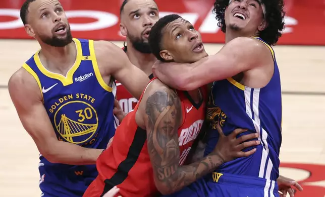 Golden State Warriors' Gui Santos, right, and Houston Rockets' Jabari Smith, Jr., front, vie for rebound position during the first half of Game 1 of an NBA basketball first-round playoff series in Houston, Sunday, April 20, 2025. (Scott Strazzante/San Francisco Chronicle via AP)