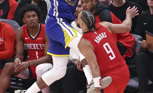 Golden State Warriors' Jimmy Butler III saves the ball from going out of bounds against Houston Rockets' Dillon Brooks (9) during the second half of Game 1 of an NBA basketball first-round playoff series in Houston, Sunday, April 20, 2025. (Scott Strazzante/San Francisco Chronicle via AP)